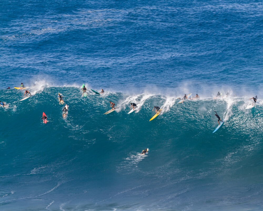 At Waimea Bay, on the island of O'ahu, surfers ride a towering giant wave on Hawaii's legendary North Shore At Waimea Bay, on the island of O'ahu, surfers ride a towering giant wave on Hawaii's legendary North Shore