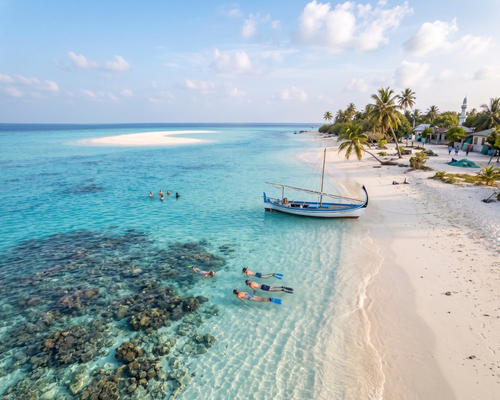Plage de sable blanc d'une île locale des Maldives, entre snorkeling dans le lagon et banc de sable à l'horizon Plage de sable blanc d'une île locale des Maldives, entre snorkeling dans le lagon et banc de sable à l'horizon