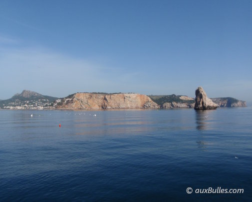 Located on the Costa Brava, the seaside resort of L'Estartit appears in the background on the left, with the rocky islet El Medallot on its right