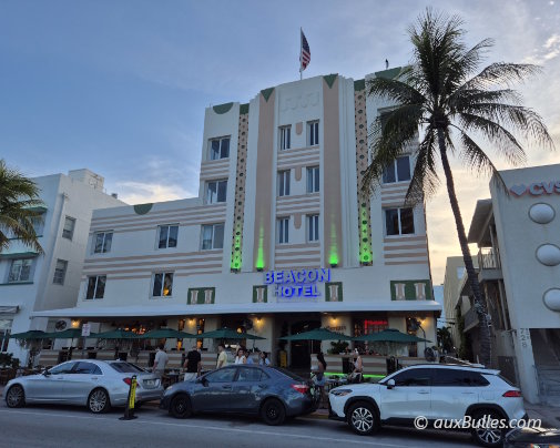 La façade Art déco du Beacon Hotel à Miami Beach, blanche et aux tons pastel, se distingue par ses lignes géométriques et ses volumes épurés