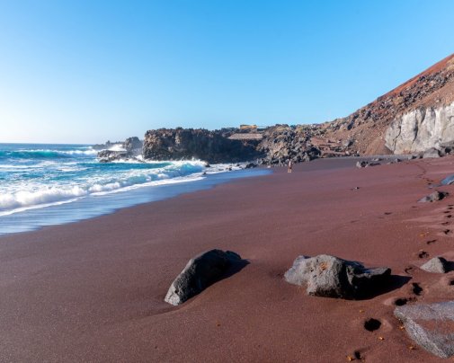 Le sable rouge volcanique intense de la plage d'El Verodal sur l'île des Canaries El Hierro
