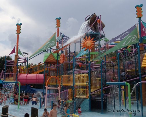 A water play area for kids featuring splash pools, slides and a giant bucket