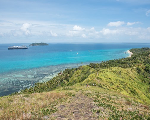 Vue vers le nord depuis l’île de Dravuni, aux Fidji, sur le lagon du Great Astrolabe Reef, avec un paquebot de croisière au large et l’île de Vanuakula