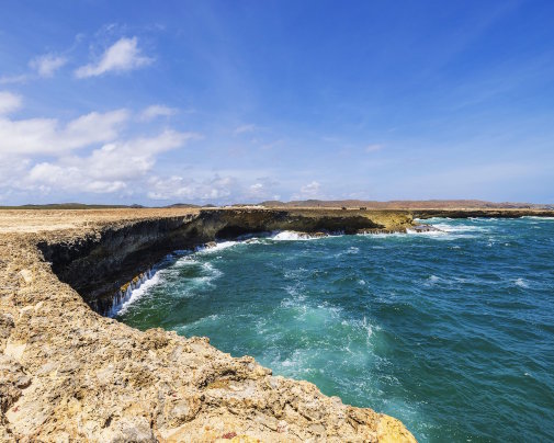 Côte rocheuse avec ses falaises du parc national d'Arikok, bordée par les eaux de la mer des Caraïbes, à Aruba Côte rocheuse avec ses falaises du parc national d'Arikok, bordée par les eaux de la mer des Caraïbes, à Aruba