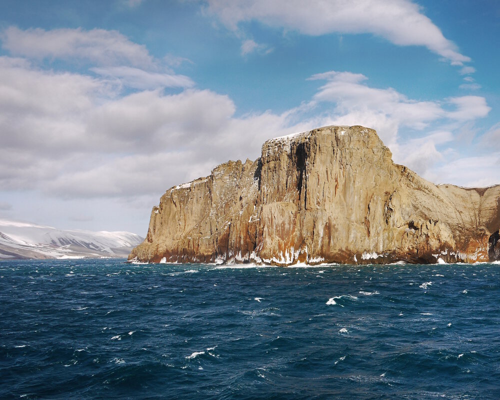 A l'approche du détroit des Forges de Neptune, l'entrée étroite de la caldeira volcanique engloutie, visible sur le côté gauche des falaises rocheuses sur l'île de la Déception dans les îles Shetland du Sud en Antarctique.