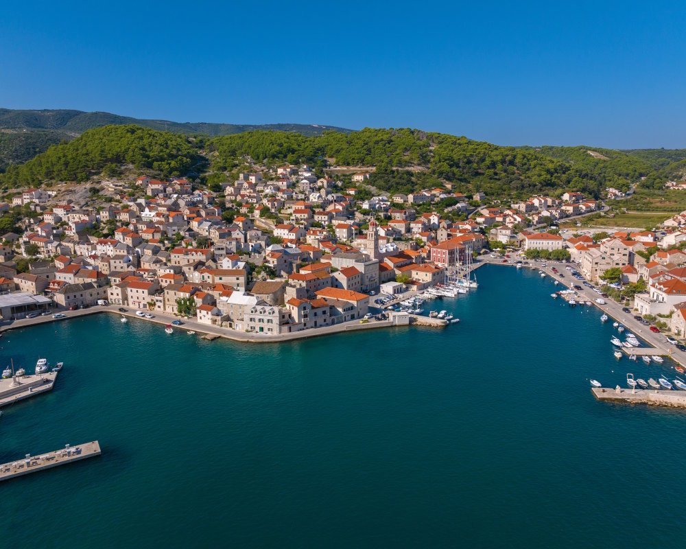 Vue aérienne du front de mer de Pučišća, village traditionnel de Brač aux maisons de pierre blanche Vue aérienne du front de mer de Pučišća, village traditionnel de Brač aux maisons de pierre blanche