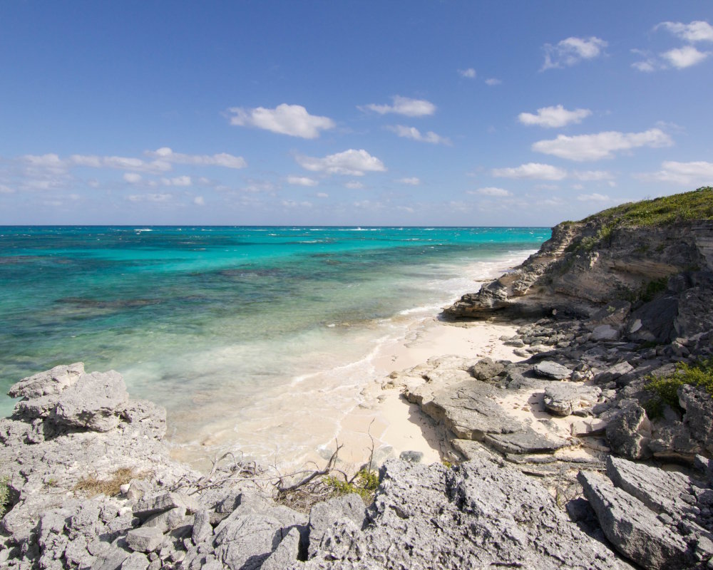 Falaises de calcaire emblématiques sur l'île de San Salvador aux Bahamas, offrant un panorama spectaculaire sur l'océan aux eaux turquoise